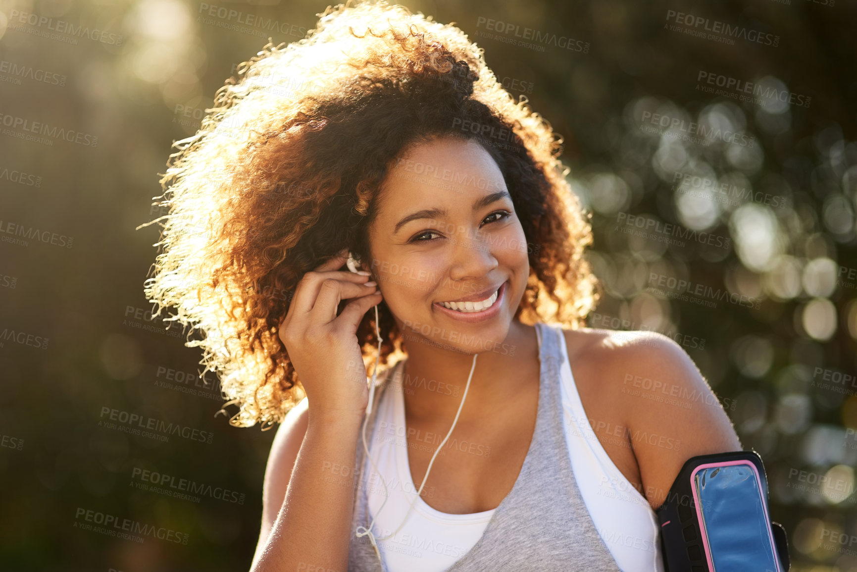 Buy stock photo Portrait of an attractive young woman listening to music while exercising outdoors