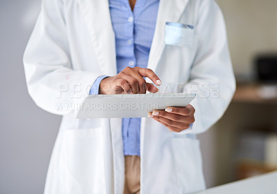 Buy stock photo Cropped shot of an unrecognizable young woman capturing data on her tablet in the lab