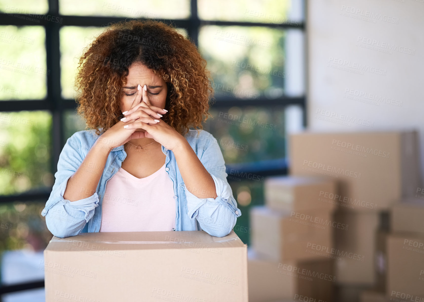 Buy stock photo Shot of a young woman looking worried after being evicted from her home