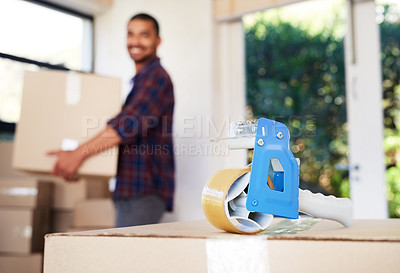 Buy stock photo Shot of a young man carrying cardboard boxes into his new home