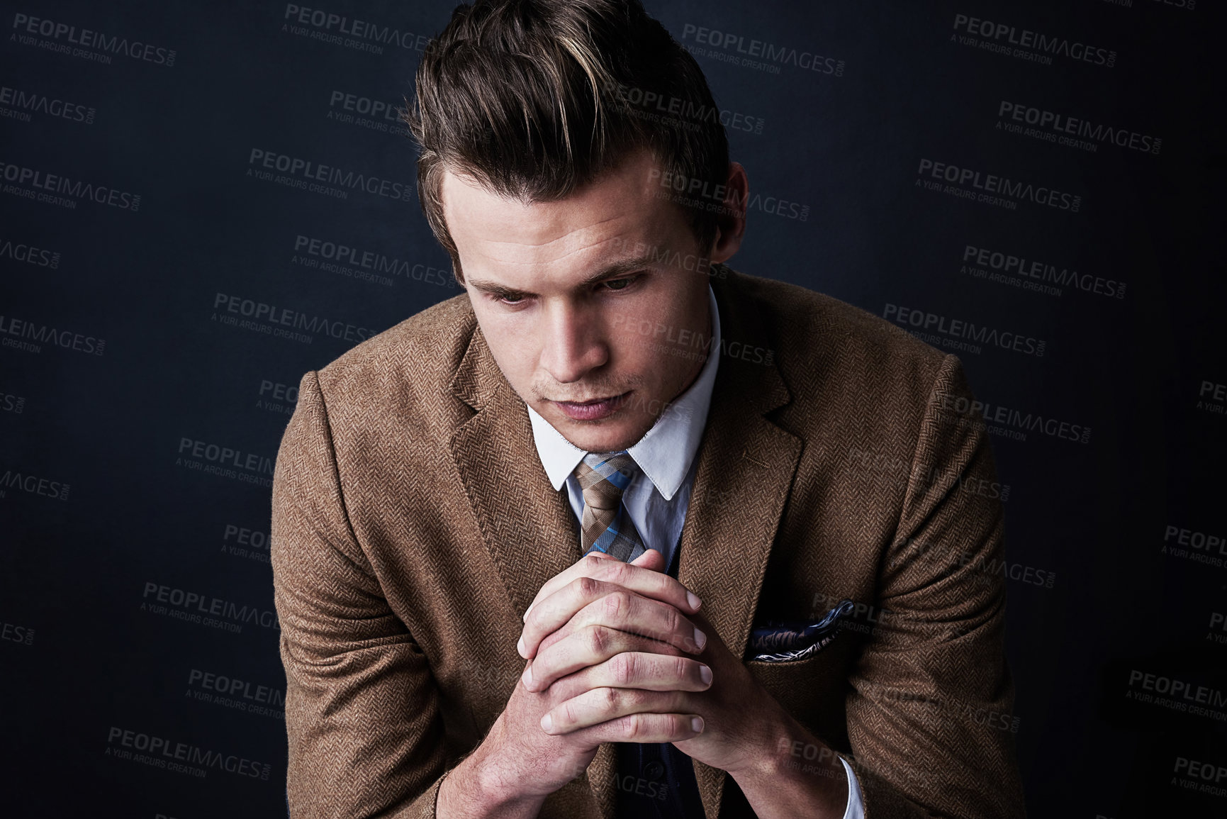 Buy stock photo Studio shot of a businessman looking worried against a dark background