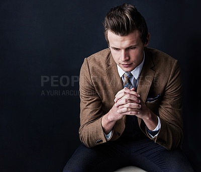 Buy stock photo Studio shot of a businessman looking worried against a dark background