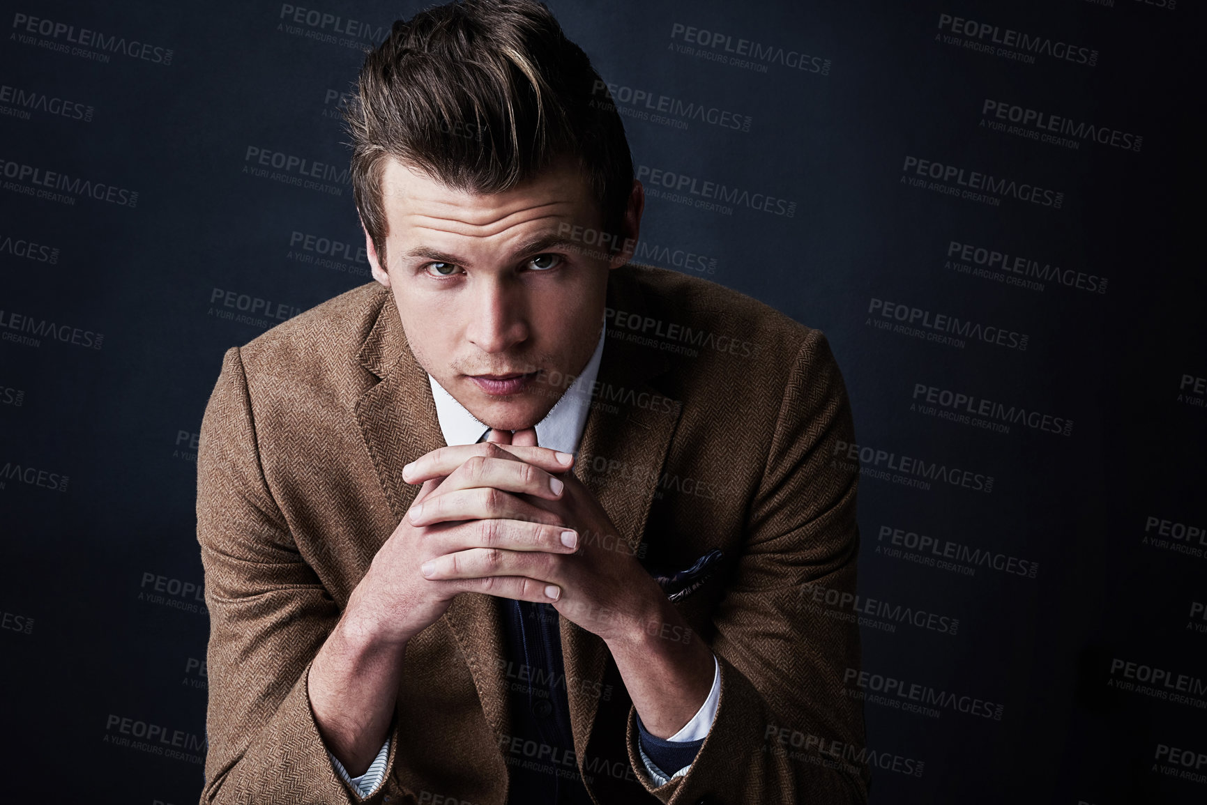 Buy stock photo Studio shot of a young businessman against a dark background