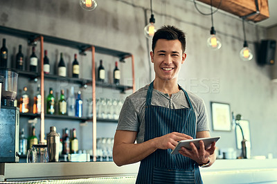 Buy stock photo Cropped portrait of a young man working on a tablet in his coffee shop