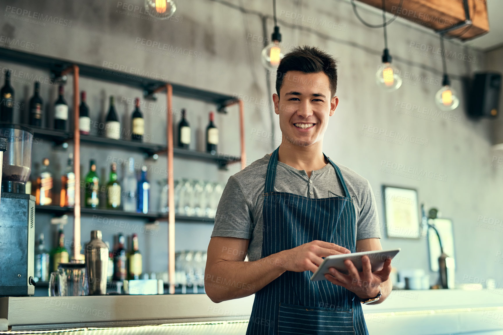 Buy stock photo Cropped portrait of a young man working on a tablet in his coffee shop