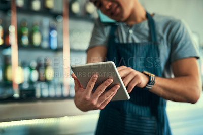 Buy stock photo Cropped shot of an unrecognizable man logging orders on his tablet