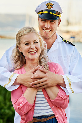 Buy stock photo Portrait of a man in a navy uniform hugging his wife while they stand on the docks