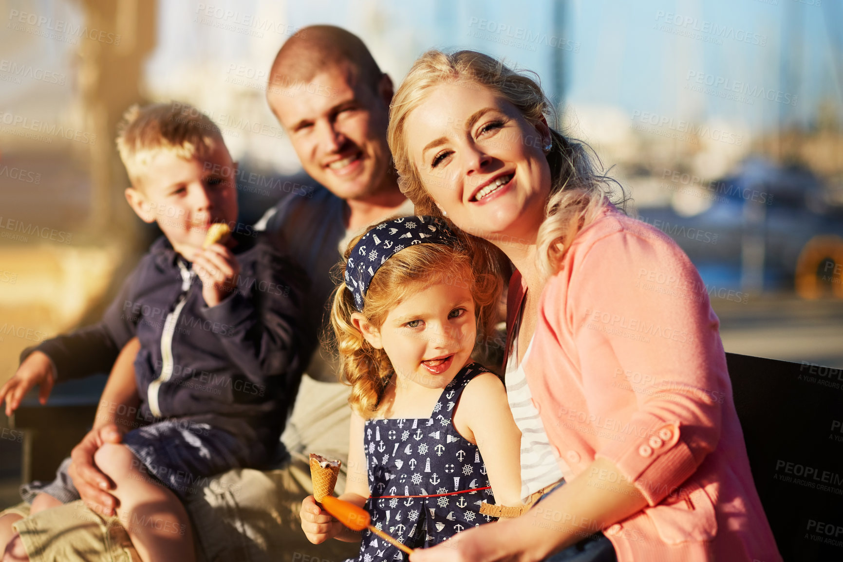 Buy stock photo Portrait of a family with young children posing together by the harbor