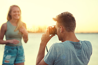 Buy stock photo Cropped shot of a young man taking a photo of his girlfriend outside