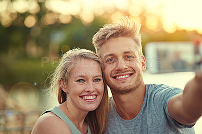 Buy stock photo Cropped shot of a young couple taking a selfie together outside