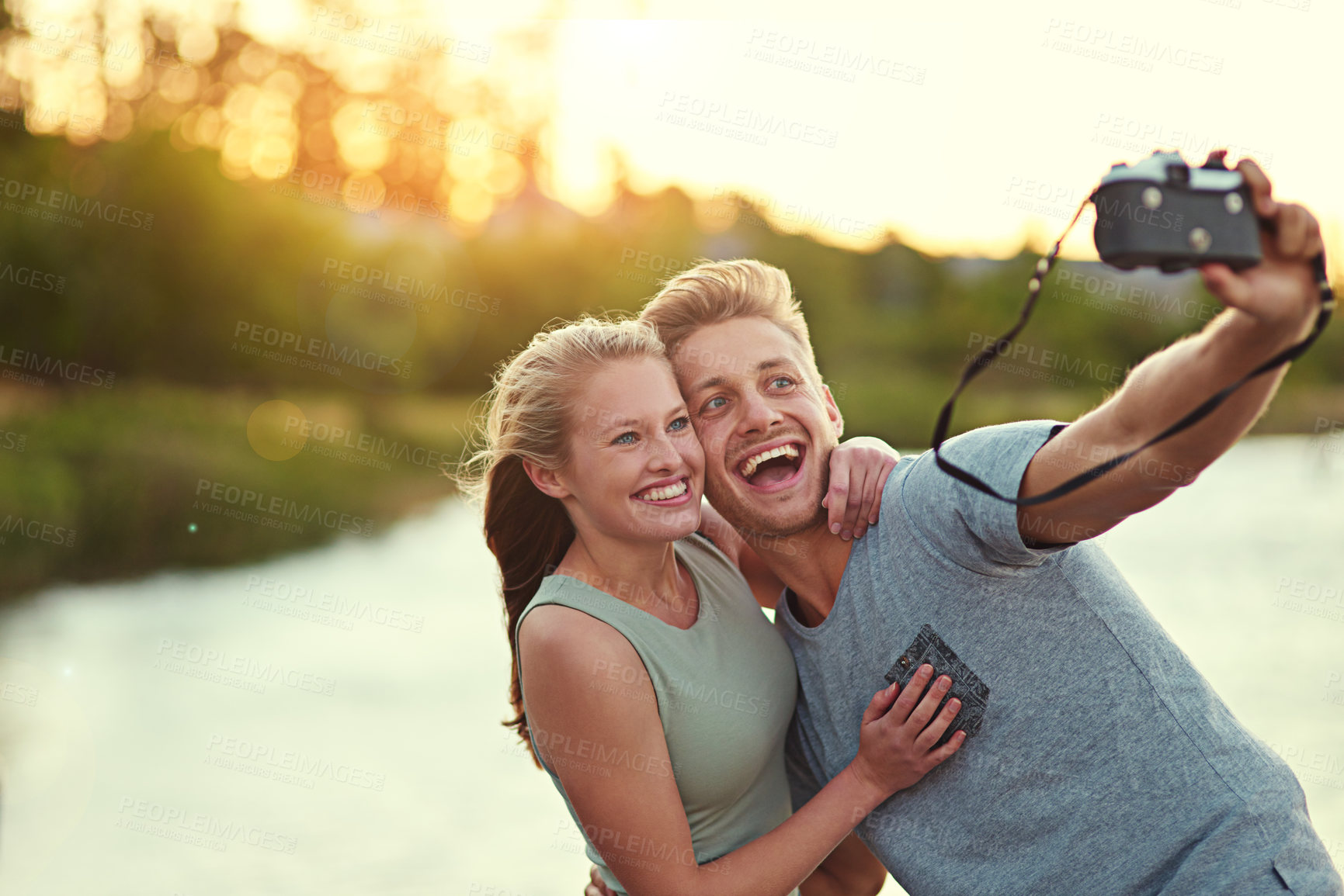 Buy stock photo Couple, camera and smile outdoor with selfie for love, bonding and support with fun in California. Relationship, people and smile for summer holiday, trip and adventure at lake with photography