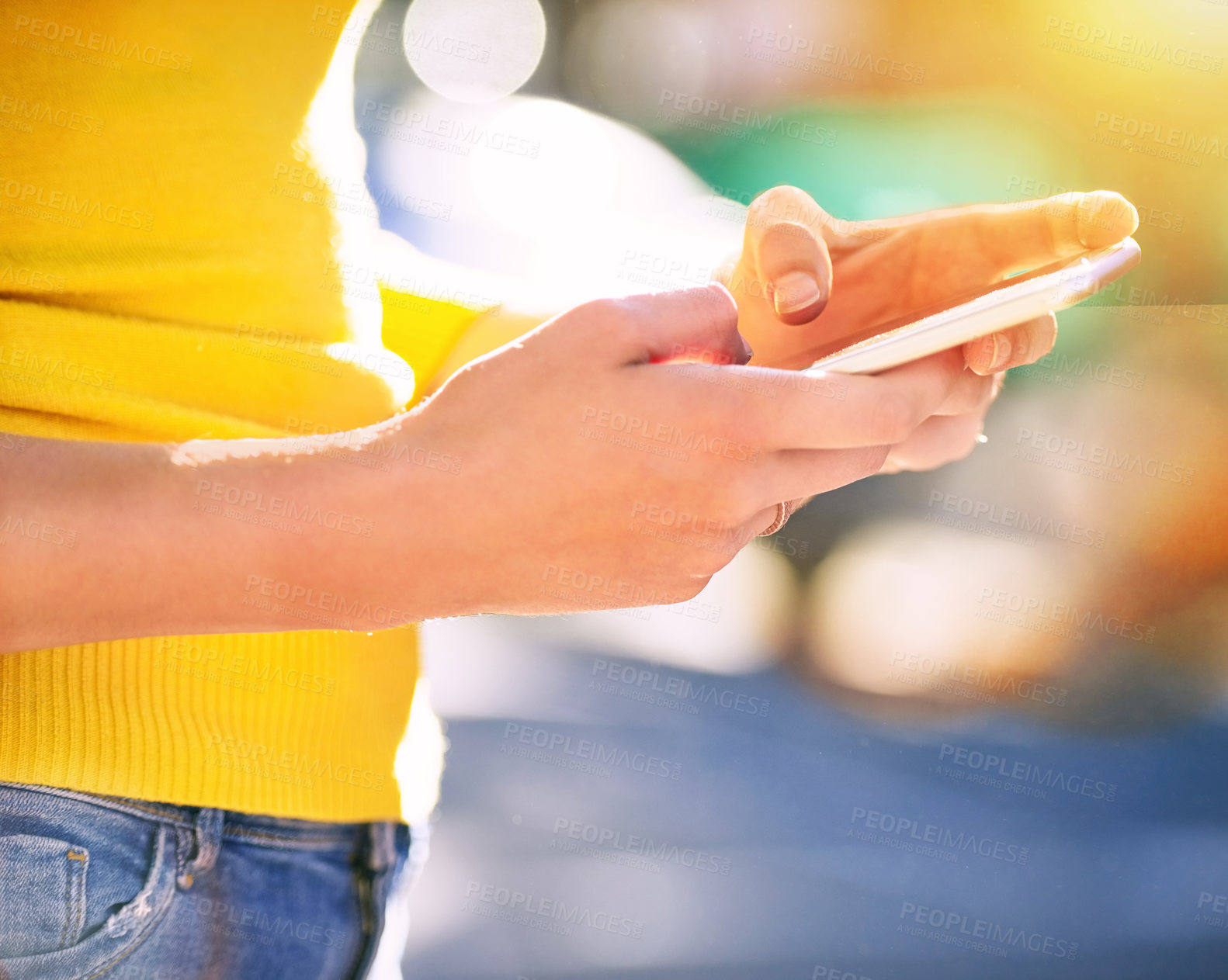 Buy stock photo Cropped shot of an unrecognizable young woman using a smartphone outside