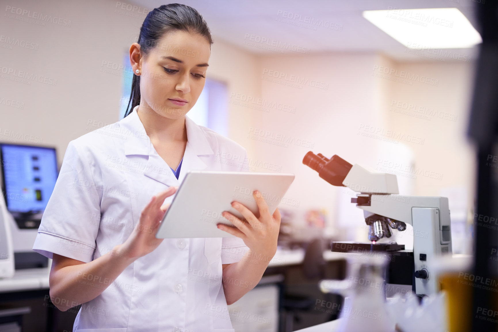 Buy stock photo Shot of a young scientist using a digital tablet while working in a laboratory