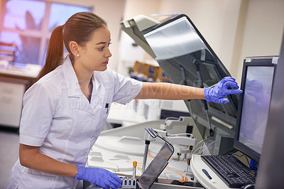 Buy stock photo Shot of a young scientist using a computer to conduct a medical test in a laboratory