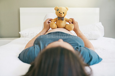 Buy stock photo Shot of a pregnant woman playing with her unborn baby's teddy bear