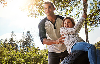 Buy stock photo Shot of a happy father pushing his daughter on a tyre swing