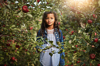 Buy stock photo Portrait of a young girl standing amongst the foliage of an apple orchard