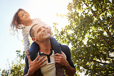 Buy stock photo Shot of a happy father and daughter enjoying a piggyback ride outdoors