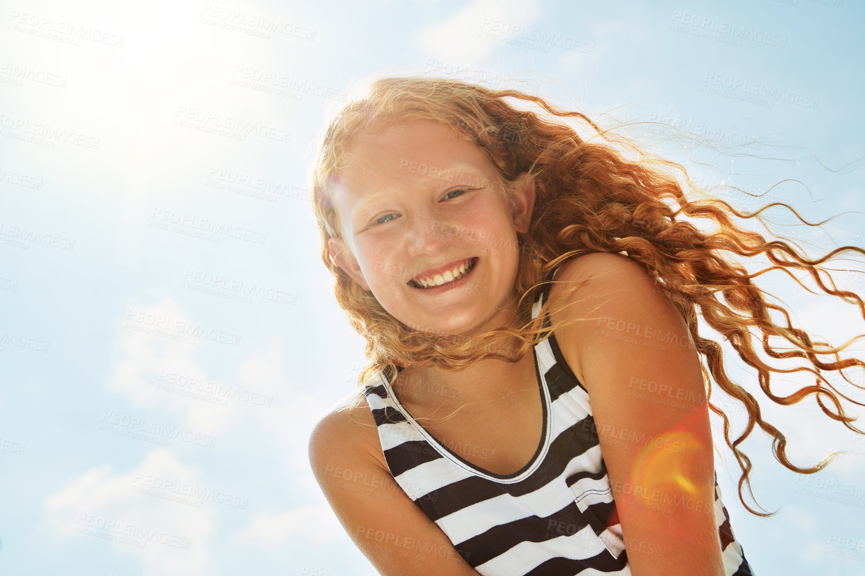 Buy stock photo Portrait of a happy girl standing outside on a bright summer’s day