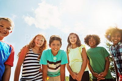 Buy stock photo Portrait of a group of diverse and happy kids hanging out together on a bright day outside