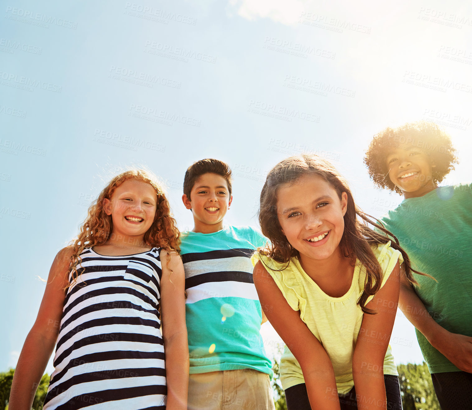 Buy stock photo Portrait of a group of diverse and happy kids hanging out together on a bright day outside