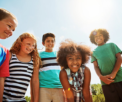 Buy stock photo Portrait of a group of diverse and happy kids hanging out together on a bright day outside