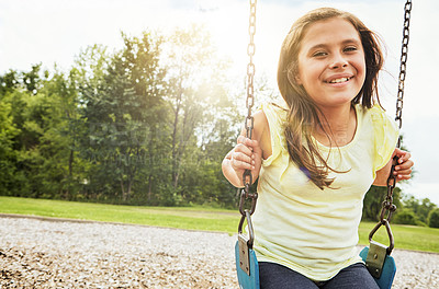 Buy stock photo Girl, portrait and smile with nature, swing and park for outdoor fun and play with fresh air. Child, tree and playground with summer, freedom and school holiday or break outside with happiness