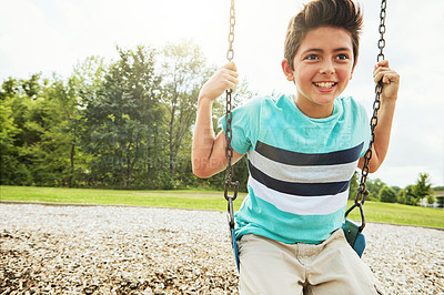 Buy stock photo Young boy, kid and smile with park, swing and nature for outdoor fun and play with fresh air. Child, development and playground with summer, freedom and school holiday or break outside with happiness