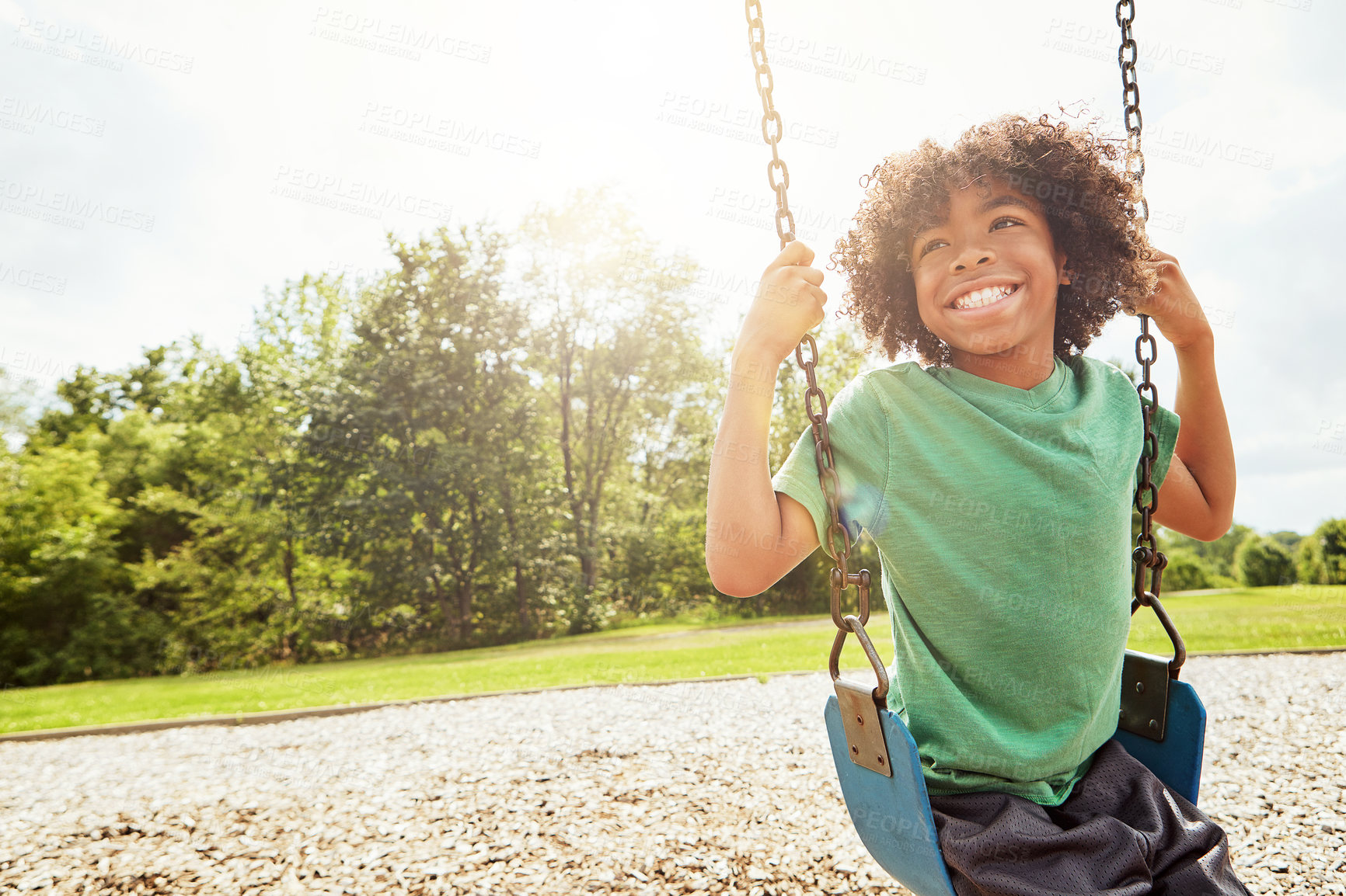 Buy stock photo Happy, nature and boy kid on swing in park for fun, adventure and play time on holiday or weekend trip. Smile, cute and child on motion equipment on playground in outdoor field on vacation in Brazil.