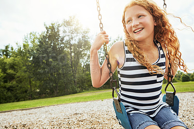 Buy stock photo Smile, nature and girl child on swing in park for fun, adventure and play time on holiday or weekend trip. Happy, cute and kid on motion equipment on playground in outdoor field on vacation in Canada