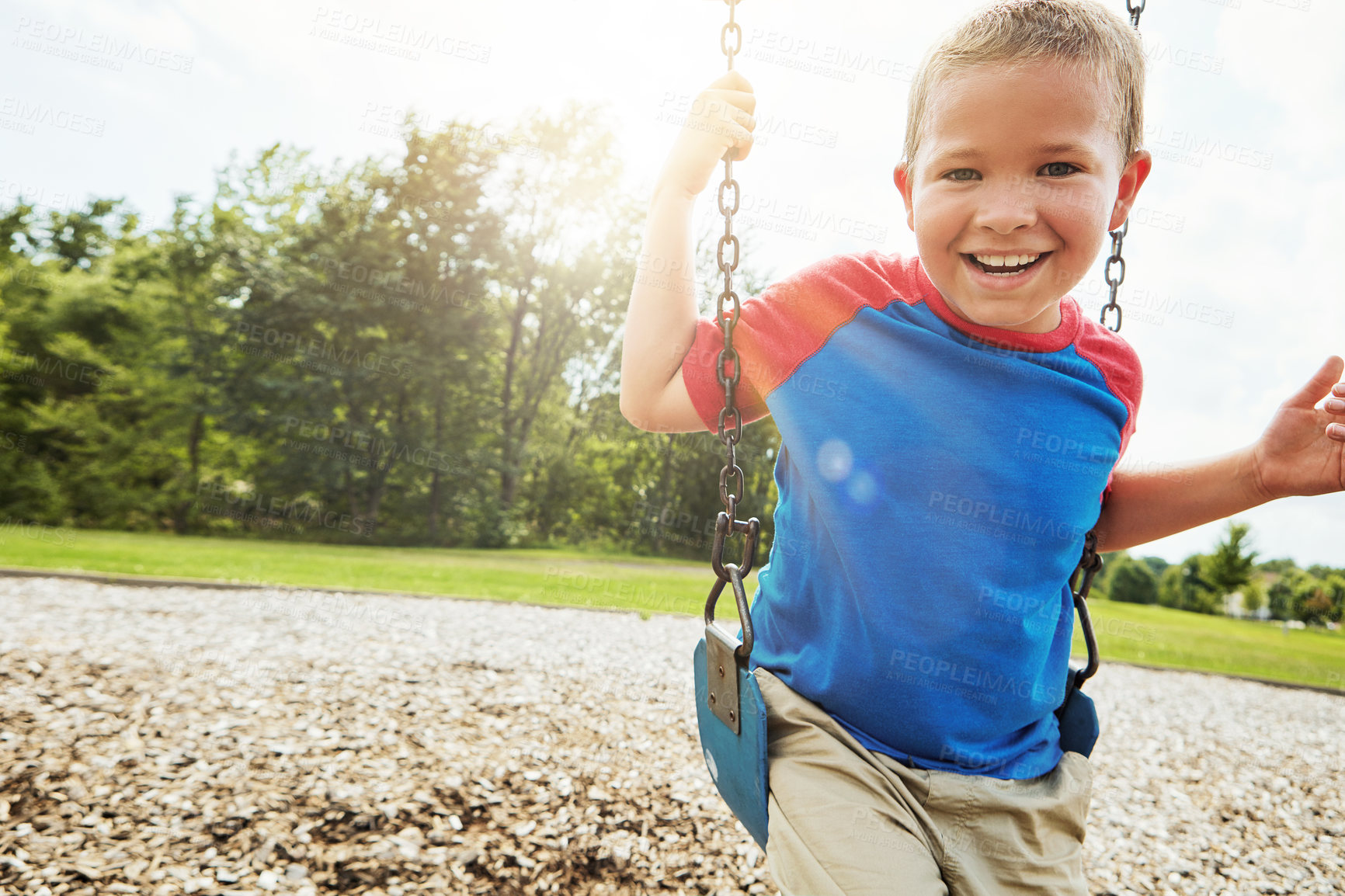 Buy stock photo Boy, portrait and laugh with park, swing and nature for outdoor fun and play with fresh air. Child, tree and playground with summer, freedom and school holiday or break outside with happiness