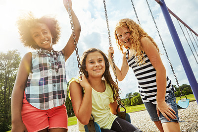 Buy stock photo Portrait of young girls playing on the swings at the park