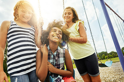 Buy stock photo Cropped shot of young girls playing on the swings at the park