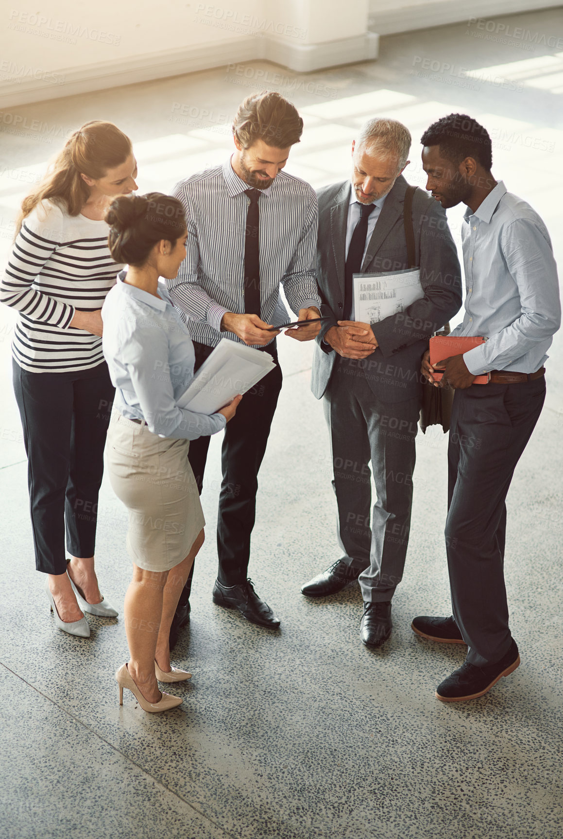 Buy stock photo High angle shot of businesspeople standing in a office lobby 