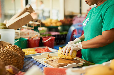 Buy stock photo Shot of an unidentifiable woman slicing fruit in a Thai food market
