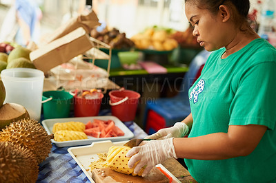 Buy stock photo Shot of a woman slicing fruit in a Thai food market