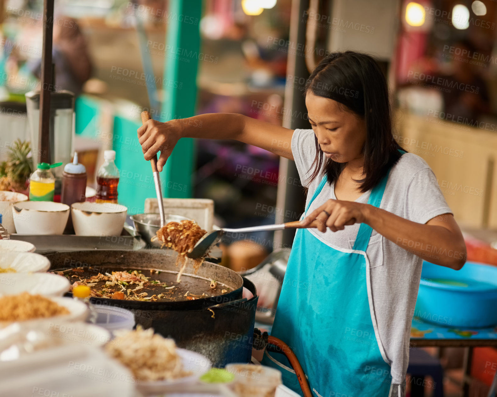 Buy stock photo Shot of a food vendor preparing a Thai dish at a food market
