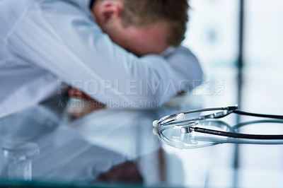 Buy stock photo Shot of a doctor experiencing stress at work