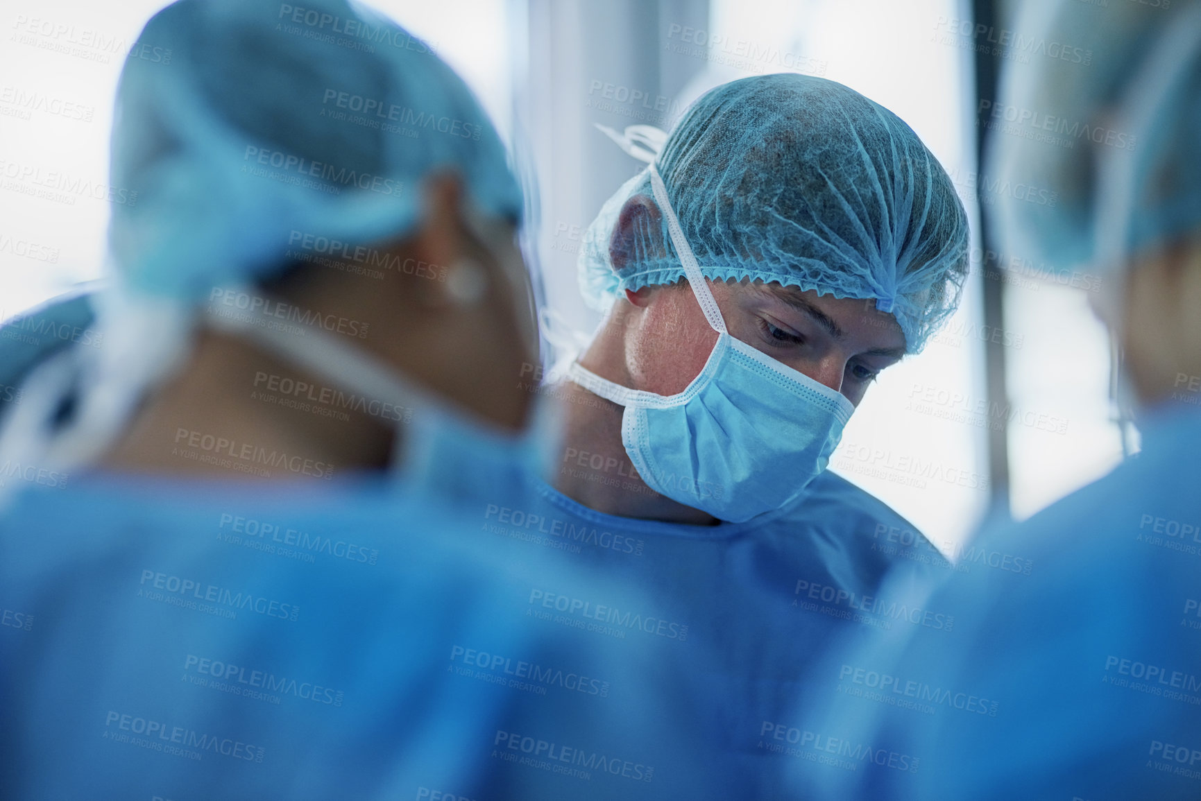 Buy stock photo Shot of a team of surgeons performing a medical procedure in an operating room