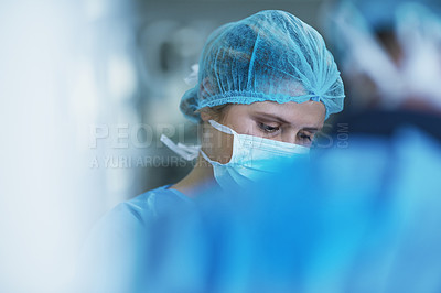 Buy stock photo Shot of a team of surgeons performing a medical procedure in an operating room