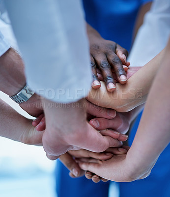 Buy stock photo Cropped shot of a team of doctors joining their hands in solidarity