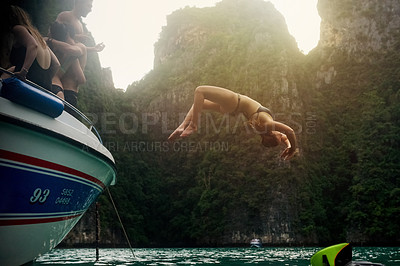 Buy stock photo Shot of a young woman doing a backflip off a boat while her friends watch