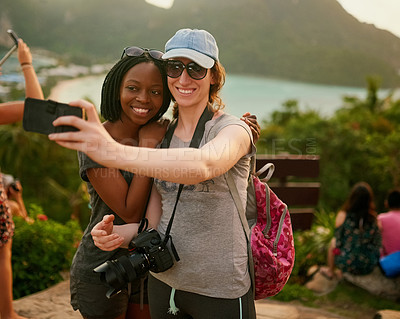Buy stock photo Portrait of two happy friends taking a selfie on an island vacation