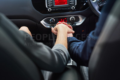 Buy stock photo Cropped shot of a couple holding hands while going for a drive
