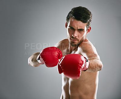 Buy stock photo Studio portrait of a young man boxing against a gray background