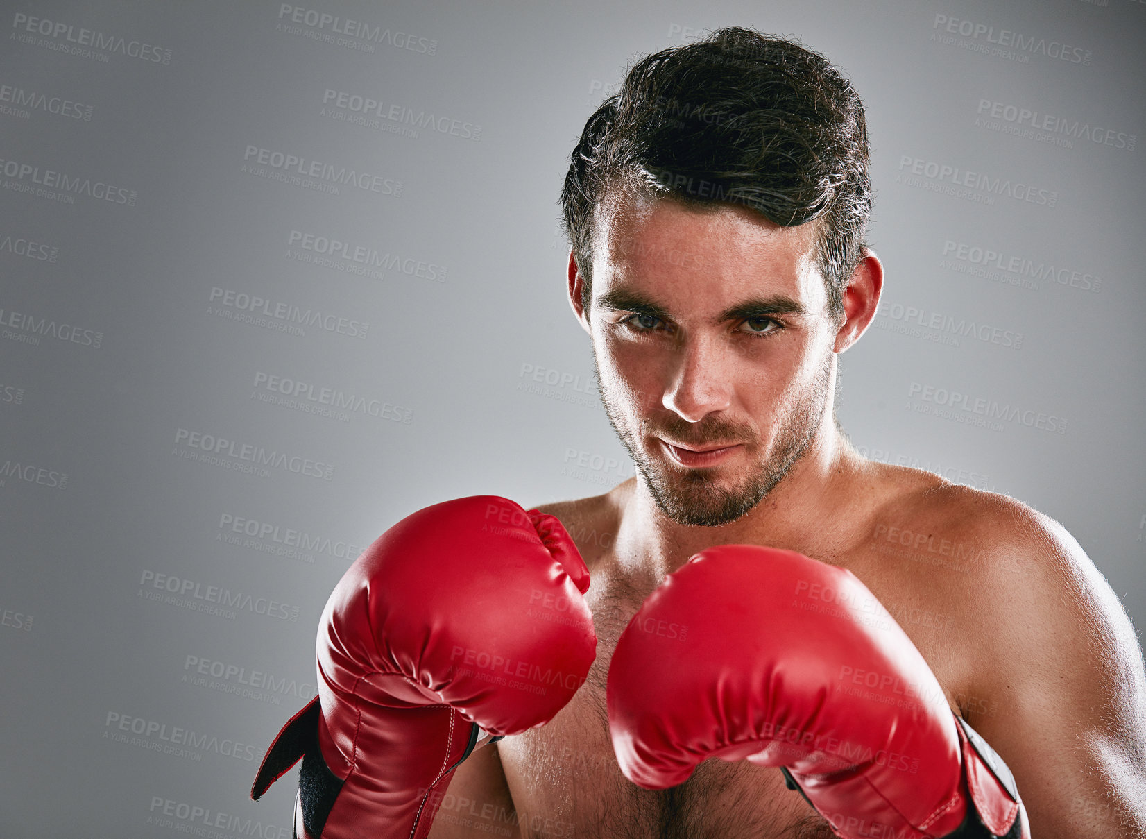 Buy stock photo Studio portrait of a young man boxing against a gray background