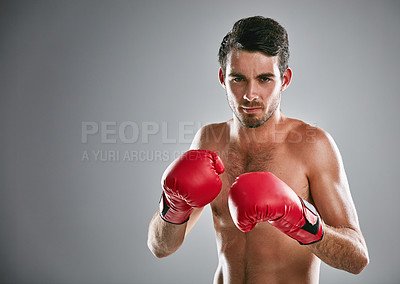 Buy stock photo Studio portrait of a young man boxing against a gray background