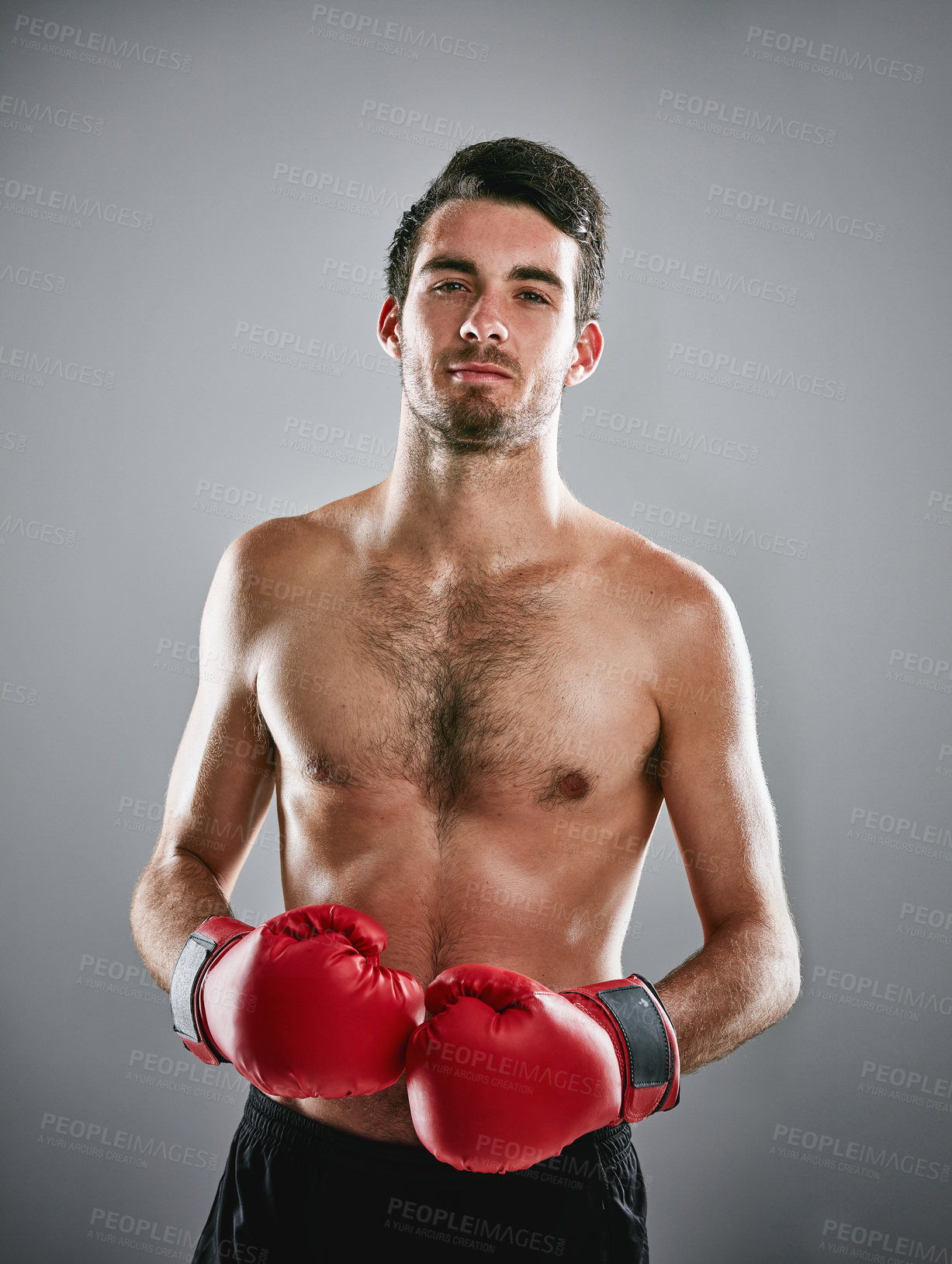 Buy stock photo Studio portrait of a young man boxing against a gray background