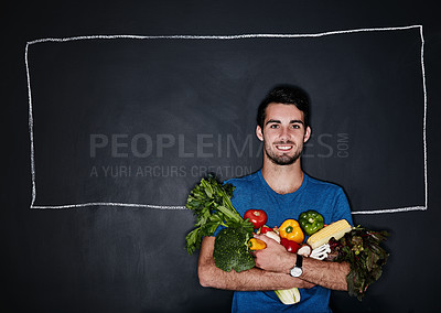 Buy stock photo Studio portrait of a young man carrying vegetables against a chalk illustration of a box on a dark background