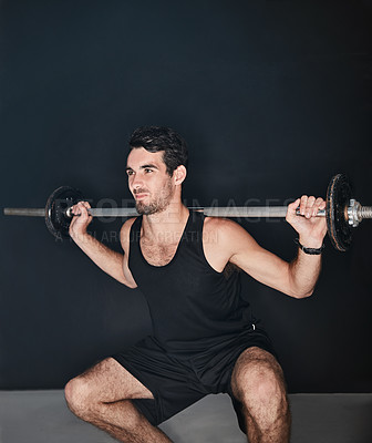 Buy stock photo Studio shot of a young man working out with a barbell against a gray background